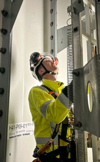 Martin inspiserer det tekniske utstyret i ført fullt verneutstyr og neonguldress.
