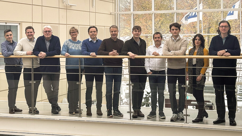 Deltagere i prosjektet KnowEarth står på gangbro og ser mot kameraet. Det er en gruppe på elleve personer.