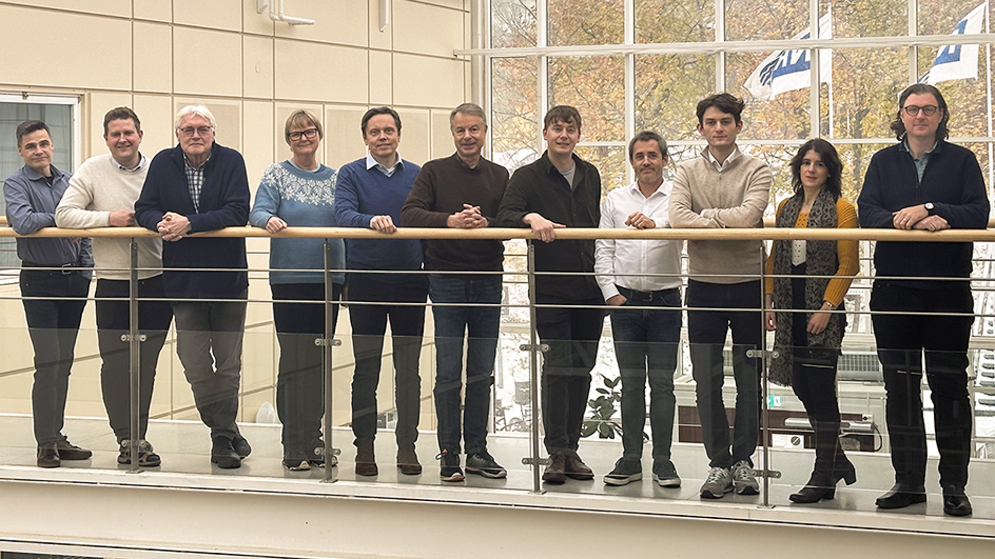 Deltagere i prosjektet KnowEarth står på gangbro og ser mot kameraet. Det er en gruppe på elleve personer.