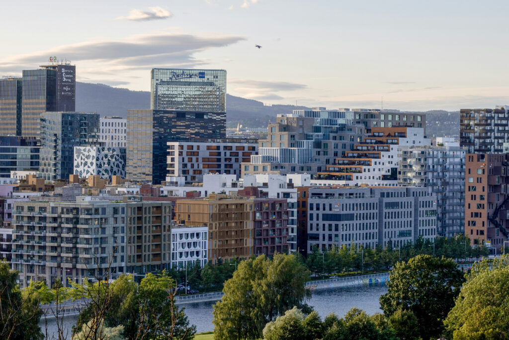 Downtown Oslo featuring green foliage, the city river and new high-rise buildings
