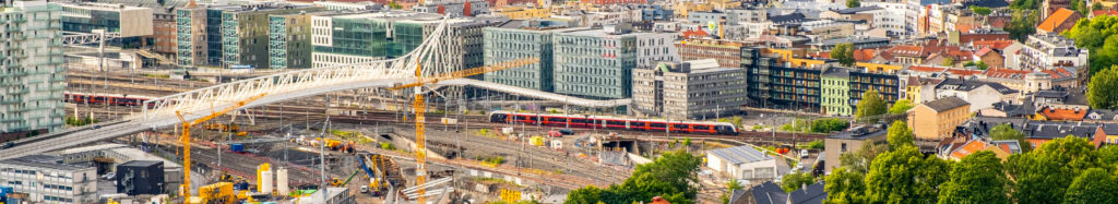 Aerial view of downtown Oslo featuring urban sprawl and transportation infrastructure like roads and railways