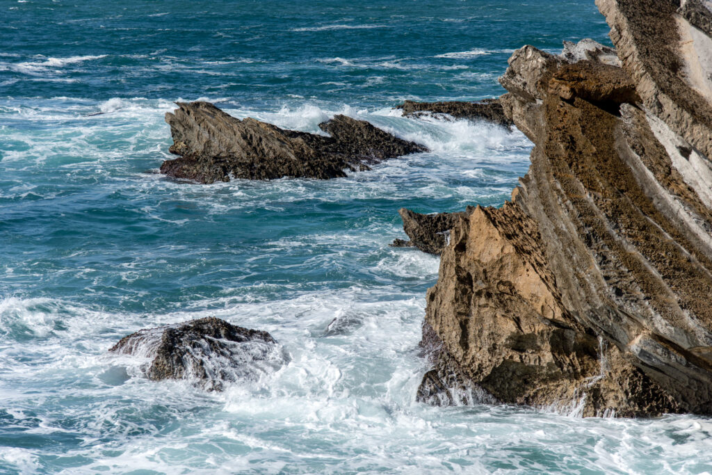 Ocean waves crashing against rocky cliffs.