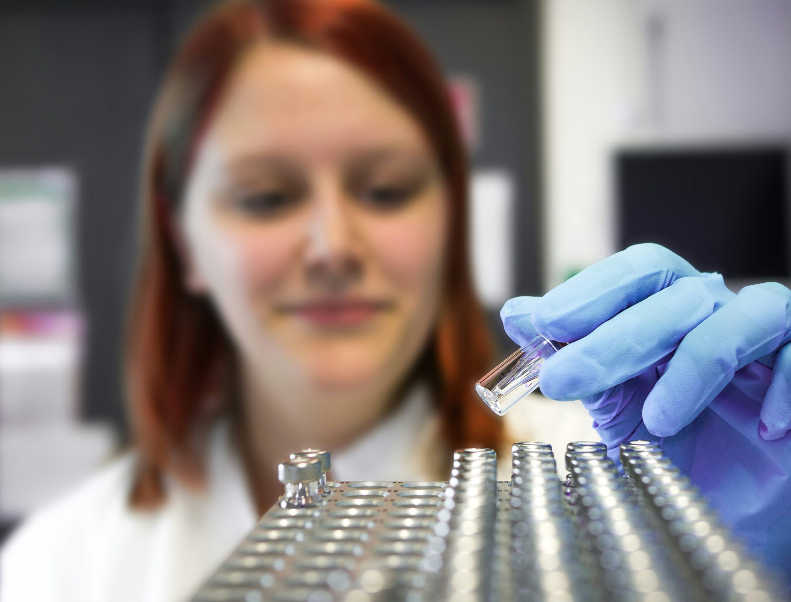 Close-up of a scientist holding vials of liquid,